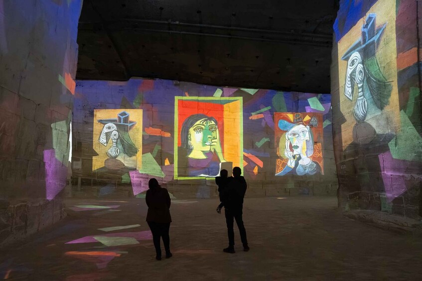 An art gallery with abstract paintings and two people observing. 4