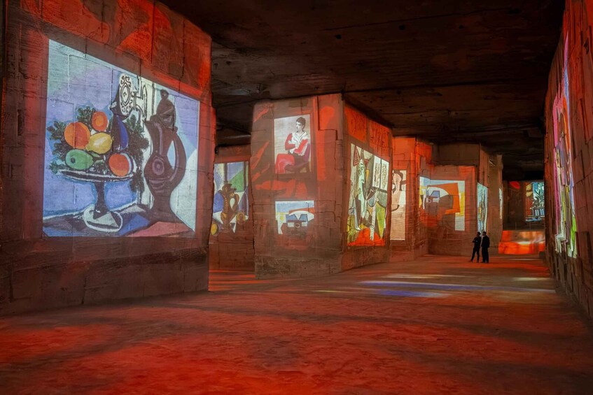 An art gallery with large paintings on the walls and a wooden floor. 1