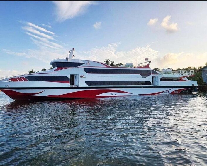 A large, modern yacht with a sleek design, red and white color scheme, and a prominent cabin structure. 1