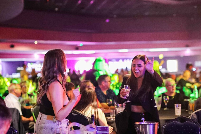 A crowded bar with people socializing and holding drinks. 5