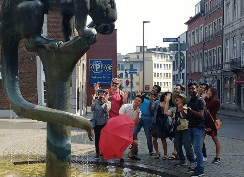 A group of people standing near a fountain with a statue of a horse. 3