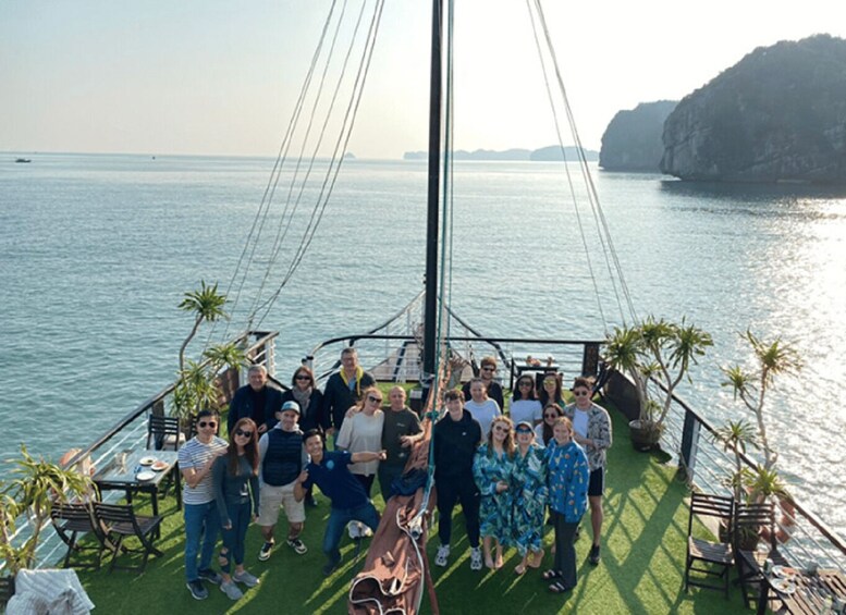 A group of people on a boat with a view of the sea and a rocky island in the background. 4