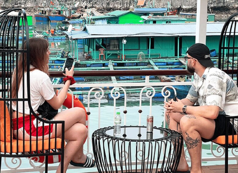 Two people sitting on a bench by a waterfront with boats in the background. 2