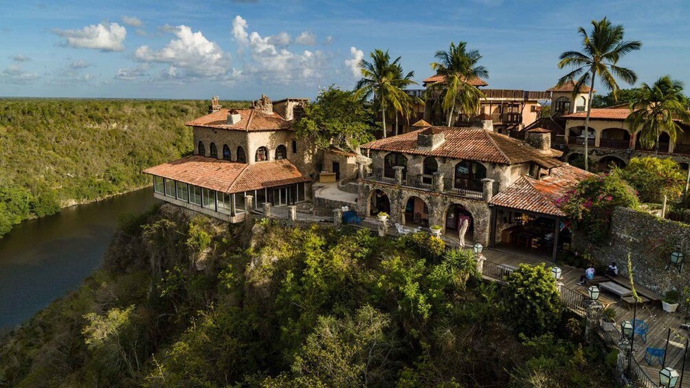 A coastal estate with multiple buildings, a river, and lush greenery. 2