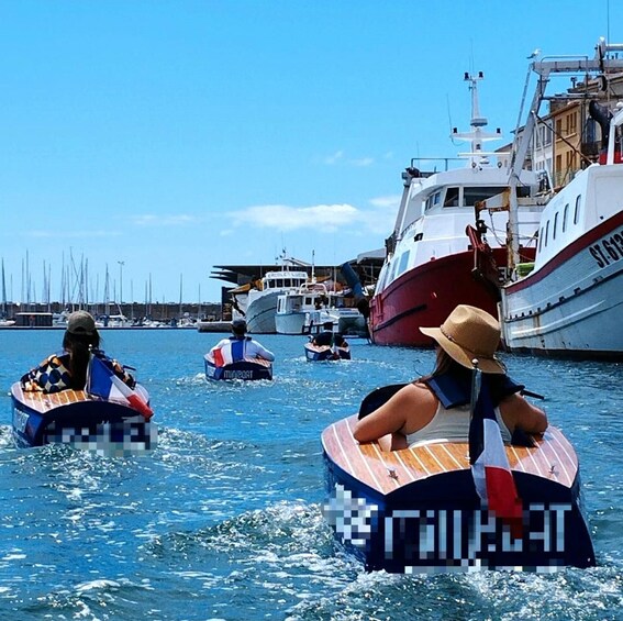 People on inflatable boats in a marina with larger boats docked in the background. 1