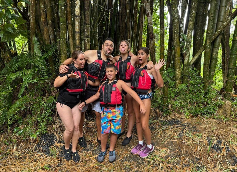 A group of people in a forested area with bamboo trees and ferns. 4