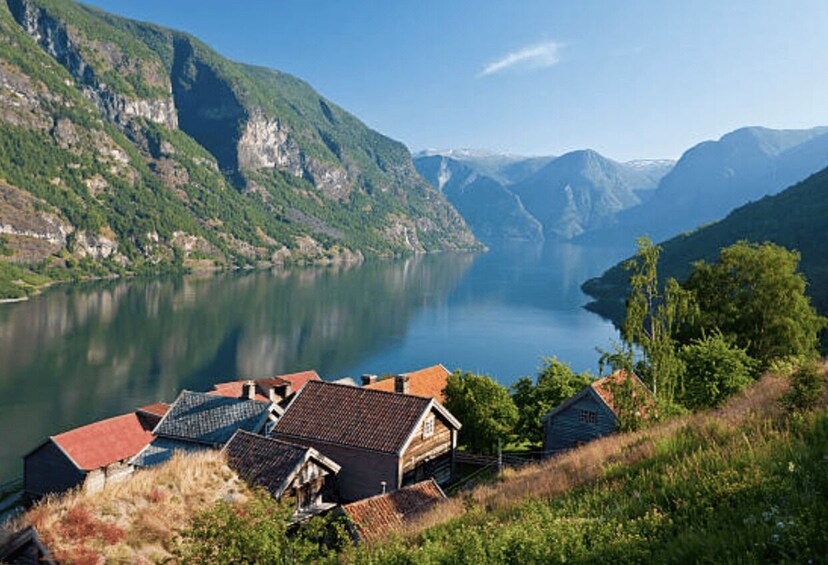 A serene lake surrounded by mountains, with traditional houses near the water's edge. 4