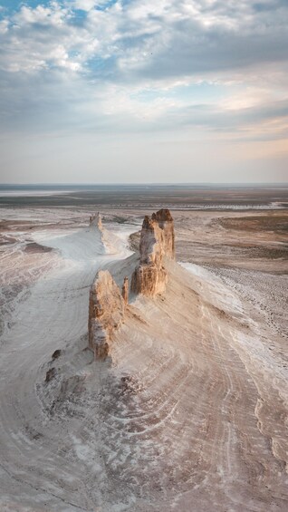 A desert landscape with prominent rock formations and a vast, flat terrain extending to the horizon. 3