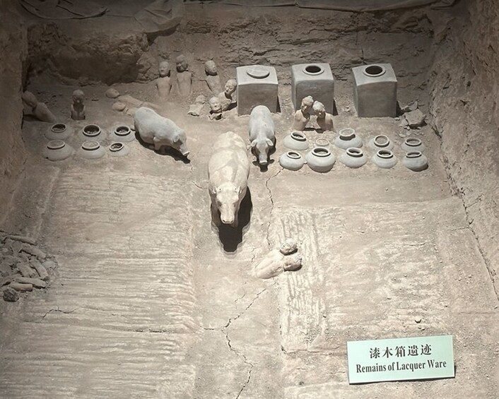 A historical site with a pig, pottery, and figures. 5