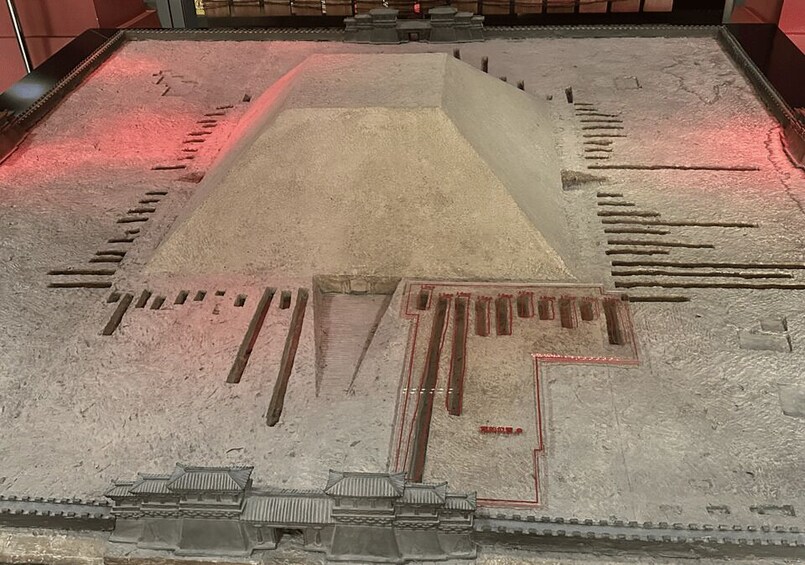 A detailed model of a traditional Chinese architectural structure with a central courtyard, raised platforms, and intricate roof designs. 2