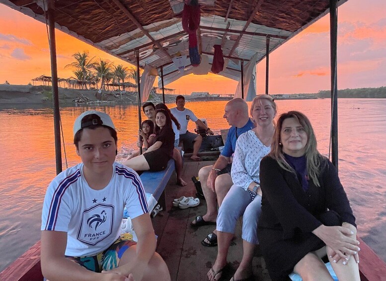 A group of people on a boat during sunset. 4
