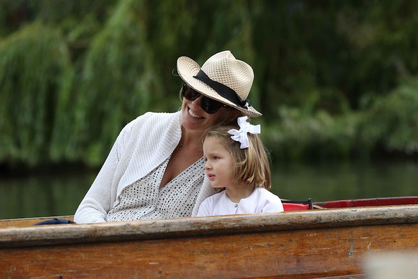 A person in a boat wearing a straw hat and sunglasses, with a child in a white outfit. 3