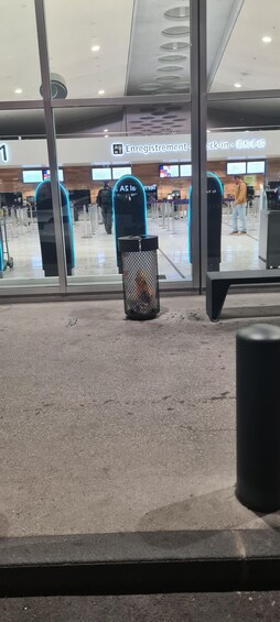 An airport registration area with a trash bin in the foreground. 3