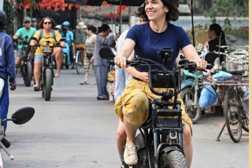 A person riding a motorcycle on a street with other motorcyclists and bicycles in the background. 3