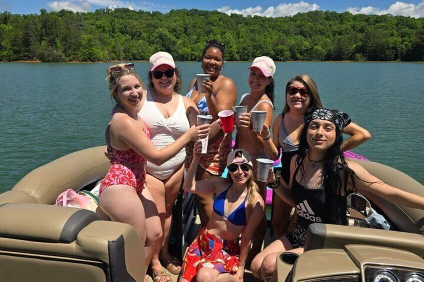 A group of people on a boat with a lake and forest in the background. 4
