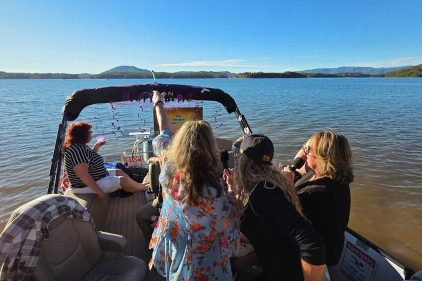 Un grupo de personas en un bote, con un lago y montañas al fondo. 5