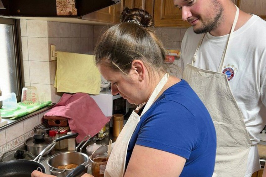 A person cooking in a kitchen with various utensils and ingredients visible. 5