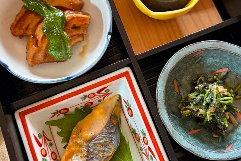 A plate of grilled fish, a bowl of green vegetables, and a bowl of sauce. 3