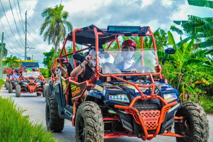 A group of off-road vehicles on a road with tropical vegetation. 1