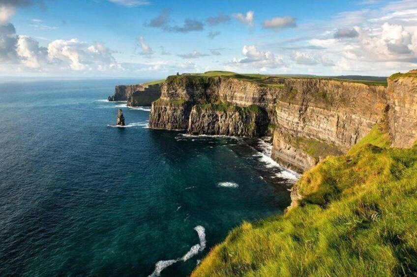A coastal cliff, ocean, and grassy terrain. 4