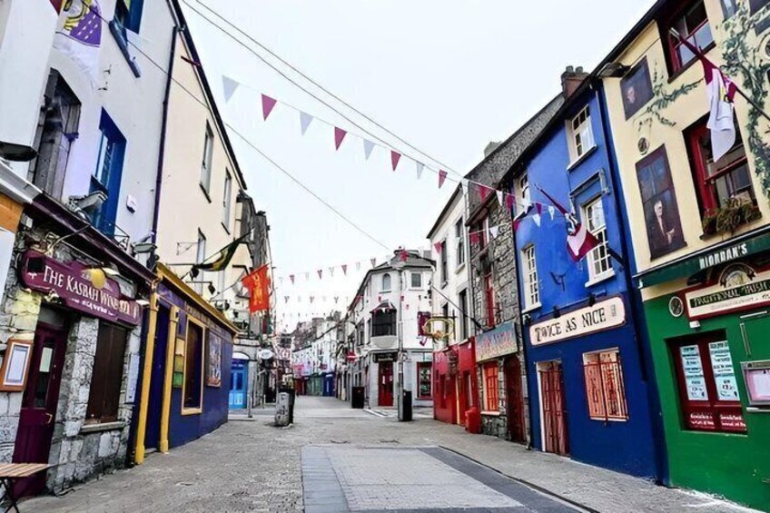 A narrow street lined with colorful buildings, some with signs like 'The Kasbah Wine Bar' and 'Twice as Nice.' 5