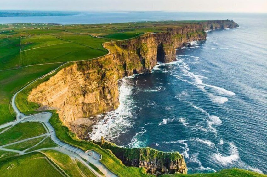 A coastal cliff with a road winding along the edge, overlooking the ocean. 1
