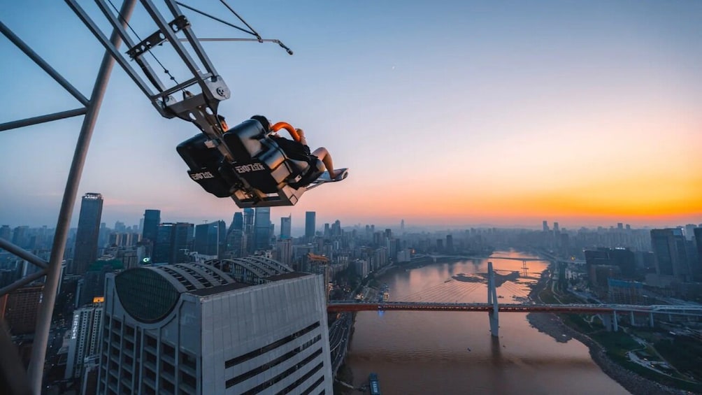 A cable car in motion, a city skyline, a river, and a sunset. 3