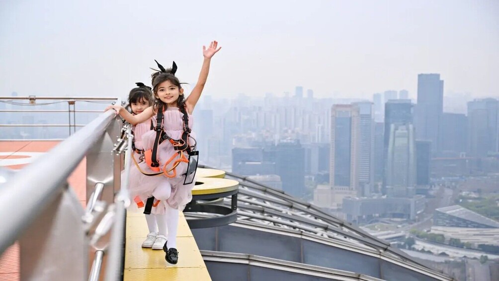 Two people on a high platform with a cityscape in the background. 4