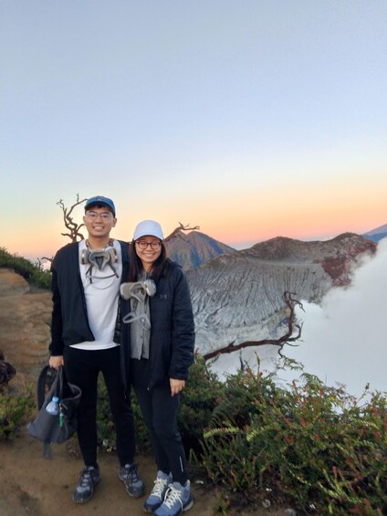 Two people standing on a trail with a mountainous landscape in the background. 4