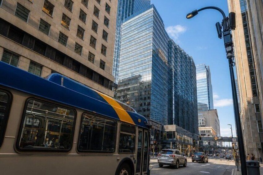A city street with a bus, tall buildings, and cars. 3
