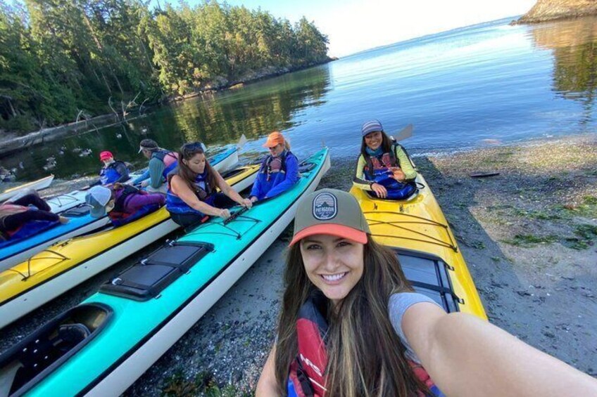 People in kayaks on a calm lake with trees in the background. 1