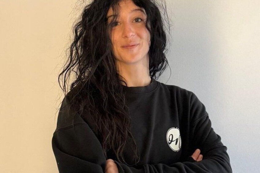 A person wearing a black sweatshirt with a white logo on the chest. 2