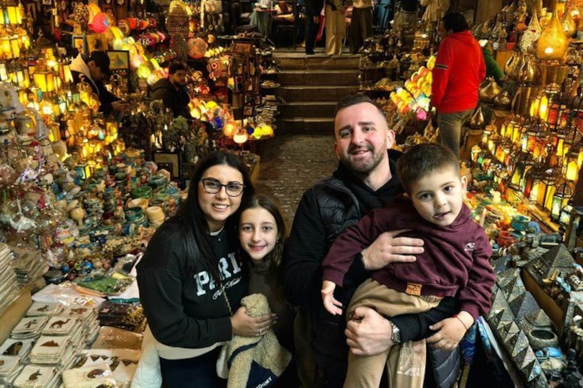 A family in a market with various items on display. 3