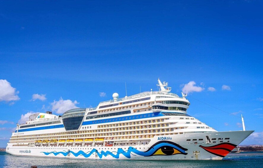 A large cruise ship with multiple decks and a distinctive blue and red design on its side. 5