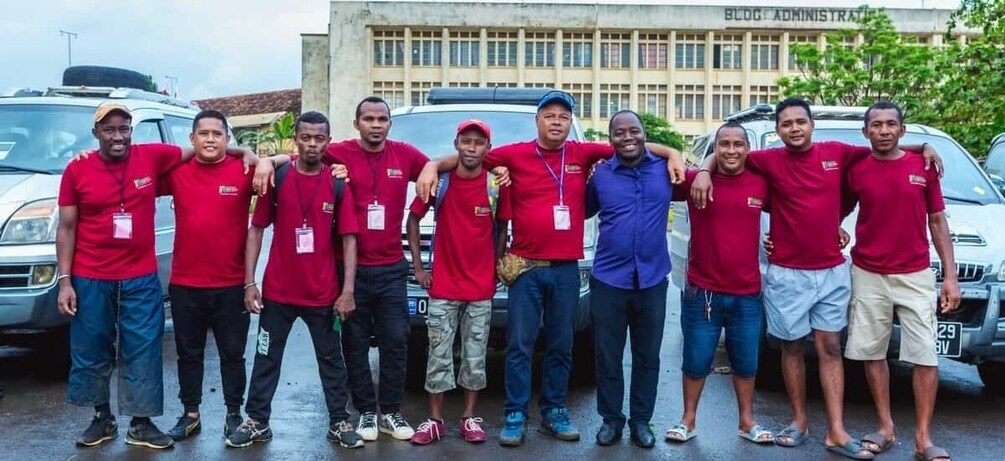A group of people in red shirts posing in front of a building with 'BLOG ADMINISTRATOR' on it. 3