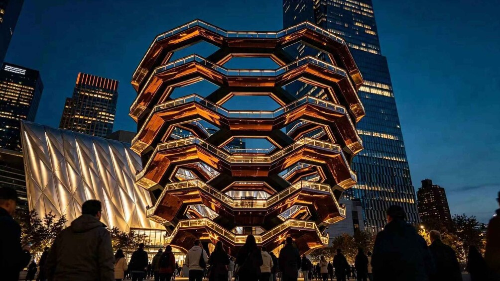 A large, illuminated hexagonal structure with people gathered around it. 1