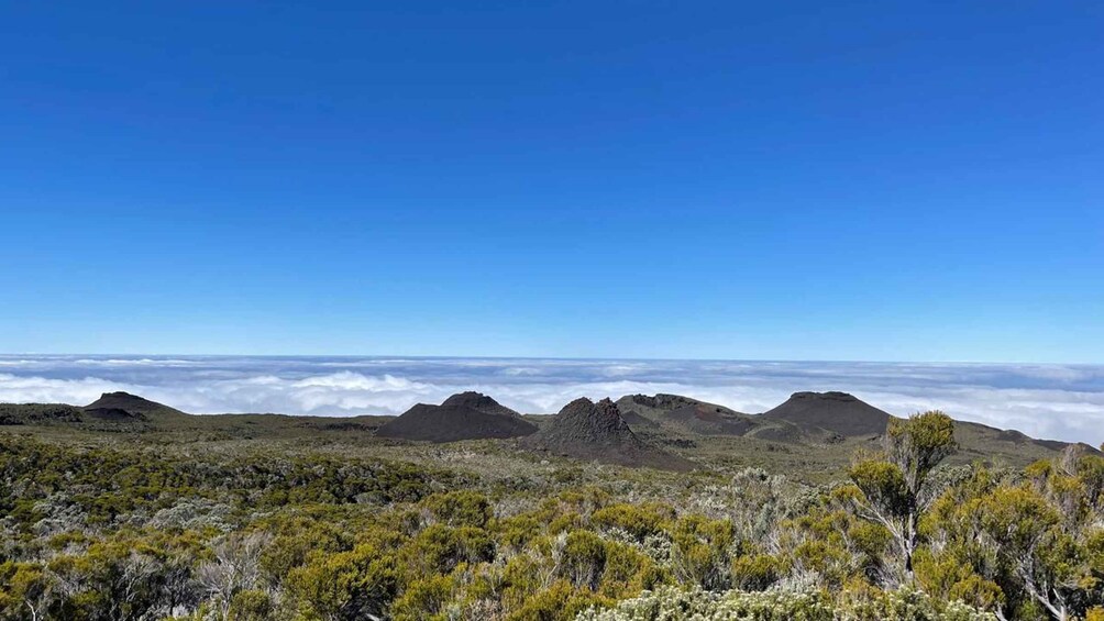Un paysage montagneux, avec un ciel dégagé et une vue sur les nuages en contrebas. 2