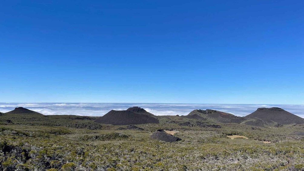 Un paisaje montañoso con poca vegetación bajo un cielo azul despejado. 3