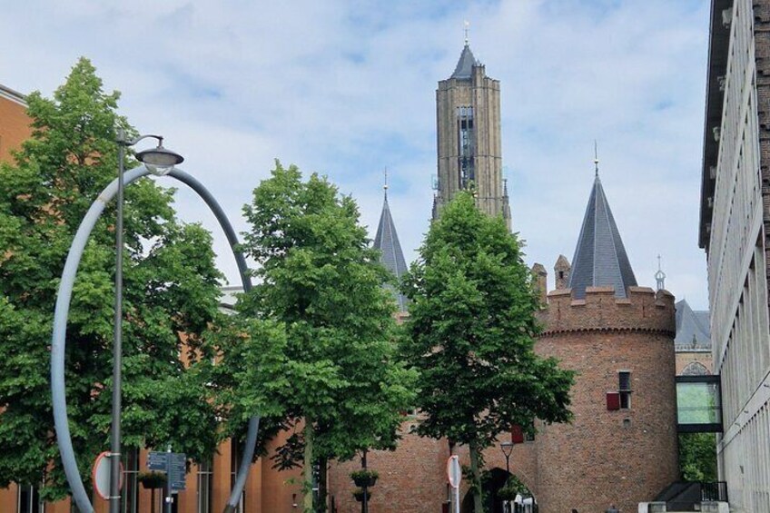 A historic building with a tall tower, surrounded by trees and modern buildings. 4