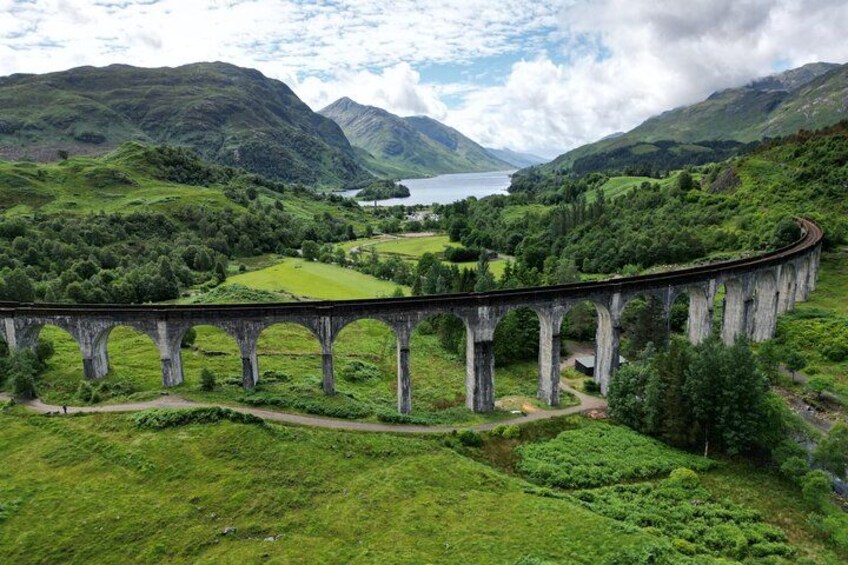 A bridge over a valley with a lake in the background. 2