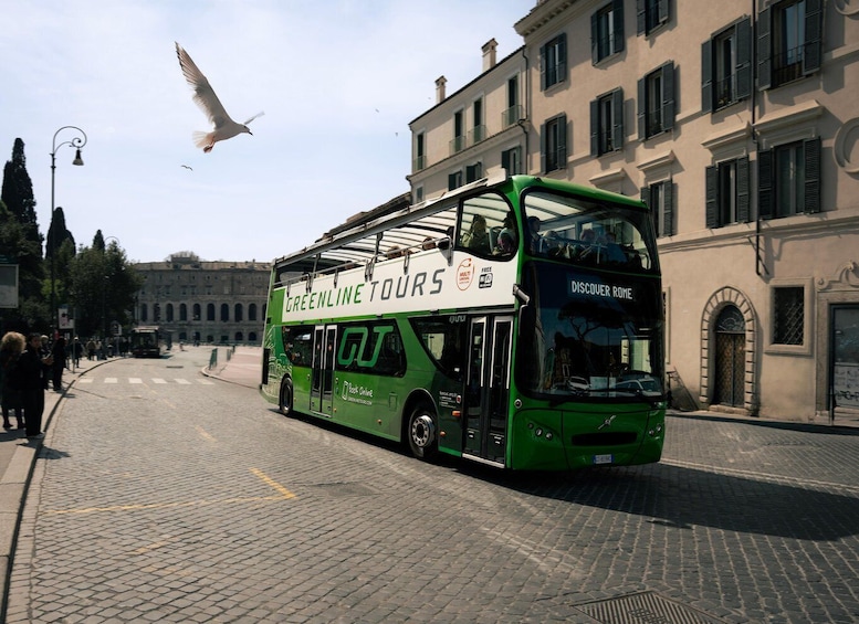 A green double-decker bus with 'Greenline Tours' and 'Discover Rome' on the side, parked on a cobblestone street. 2