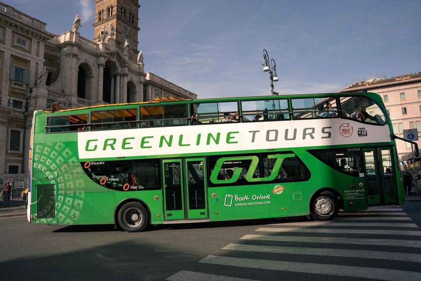A green double-decker bus with 'GREENLINE TOURS' written on the side, parked at a crosswalk with a historic building in the background. 3