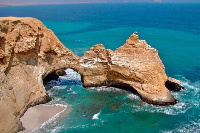 A coastal rock formation with a natural arch and turquoise waters. 5