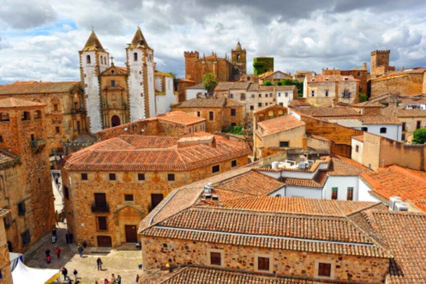 A historic town with medieval architecture, including a church with a bell tower and a fortress-like structure. 3