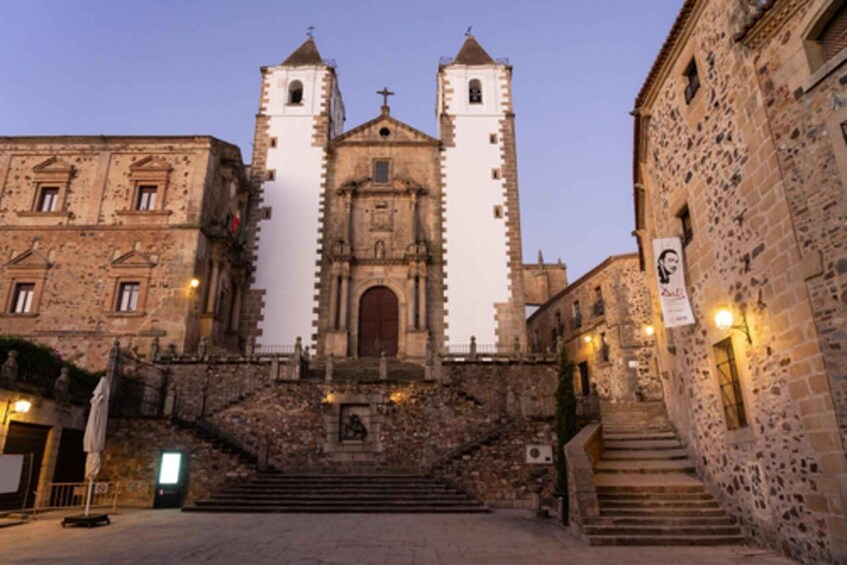 A historic church with two bell towers and a stone staircase leading to its entrance. 2