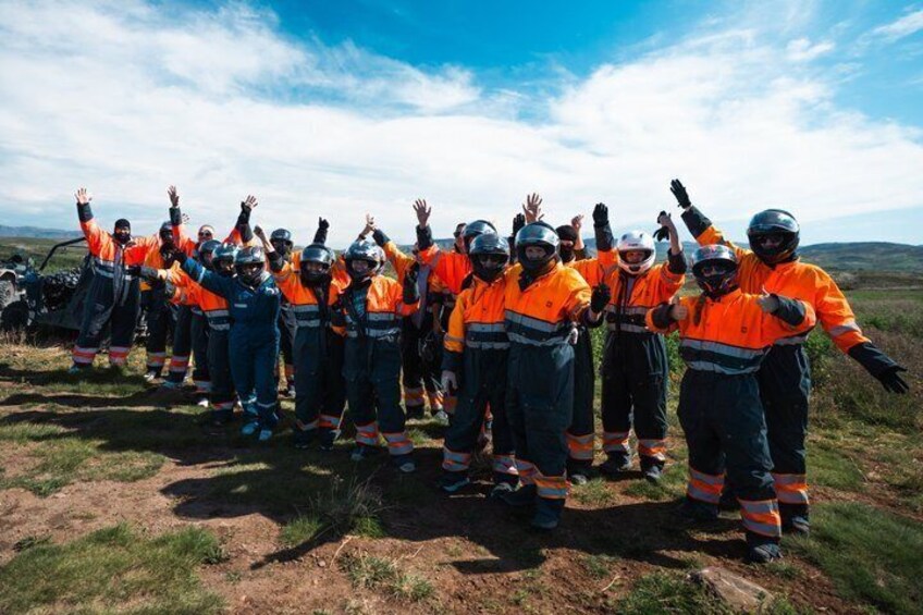 A group of people in orange and black uniforms standing on a grassy field with their arms raised. 2
