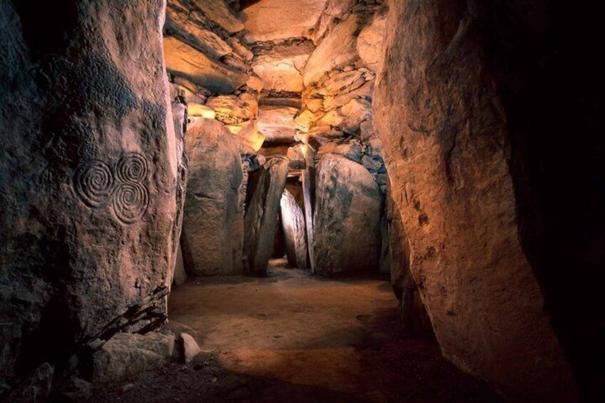 A cave with large rock formations and a narrow passageway. 2