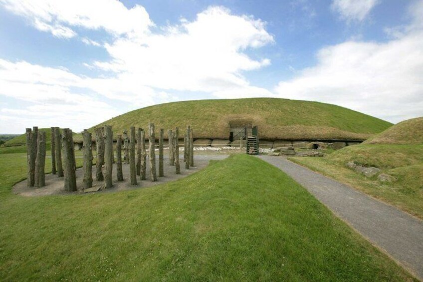 A grassy landscape with a mound and wooden posts. 3