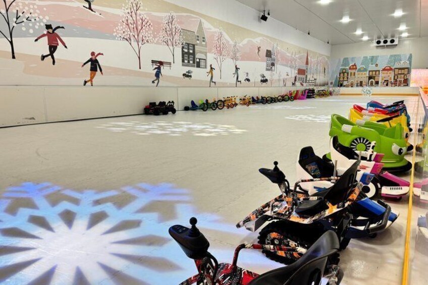An indoor skating rink with children's ice skates and a snowflake projection on the floor. 5