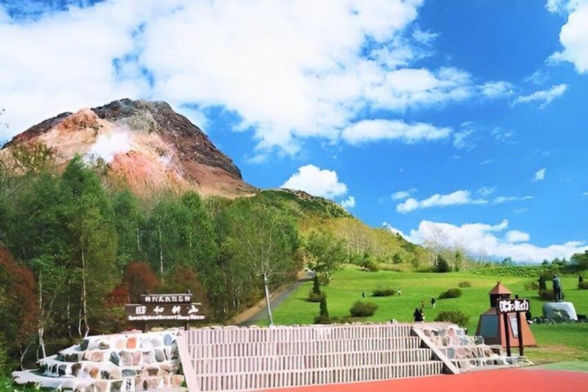 A mountain, a sign with Japanese characters, and a red-roofed structure. 4